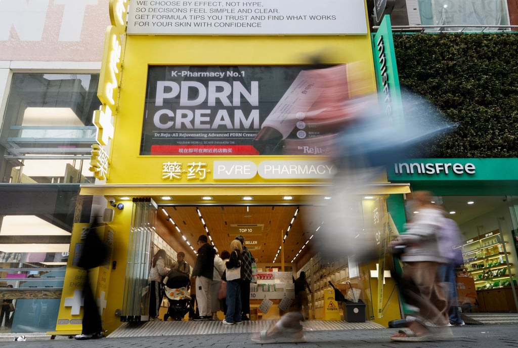 Tourists walk past a cosmetics store at Myeongdong shopping district in Seoul on Friday. Photo: Reuters