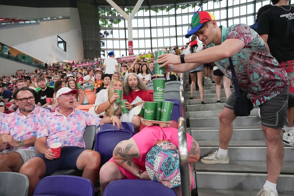 Stacking up empty beer cups on a snoozing rugby fan in the South Stand. Photo: Karma Lo