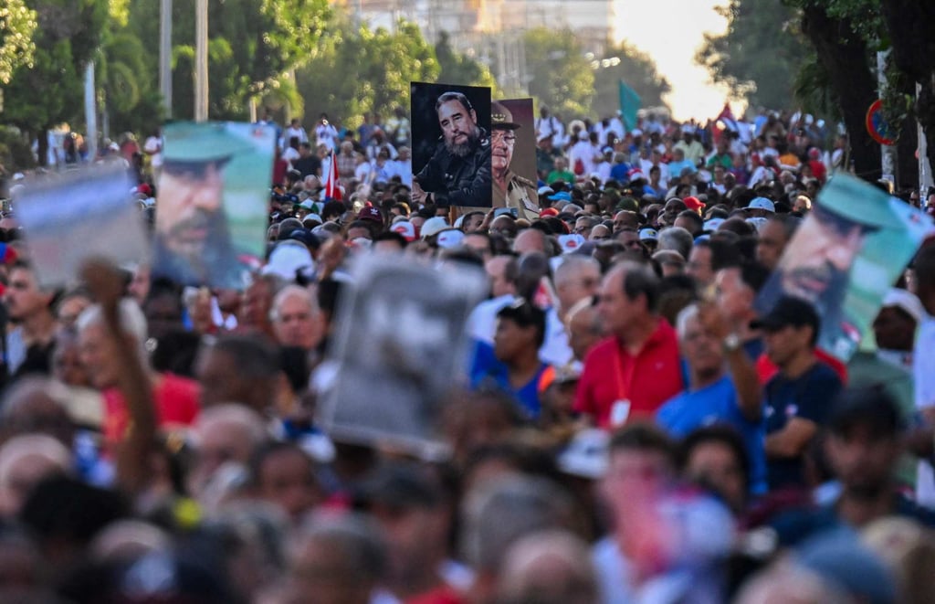 People hold pictures of late leader Fidel Castro and his brother during celebrations on Thursday. Photo: AFP