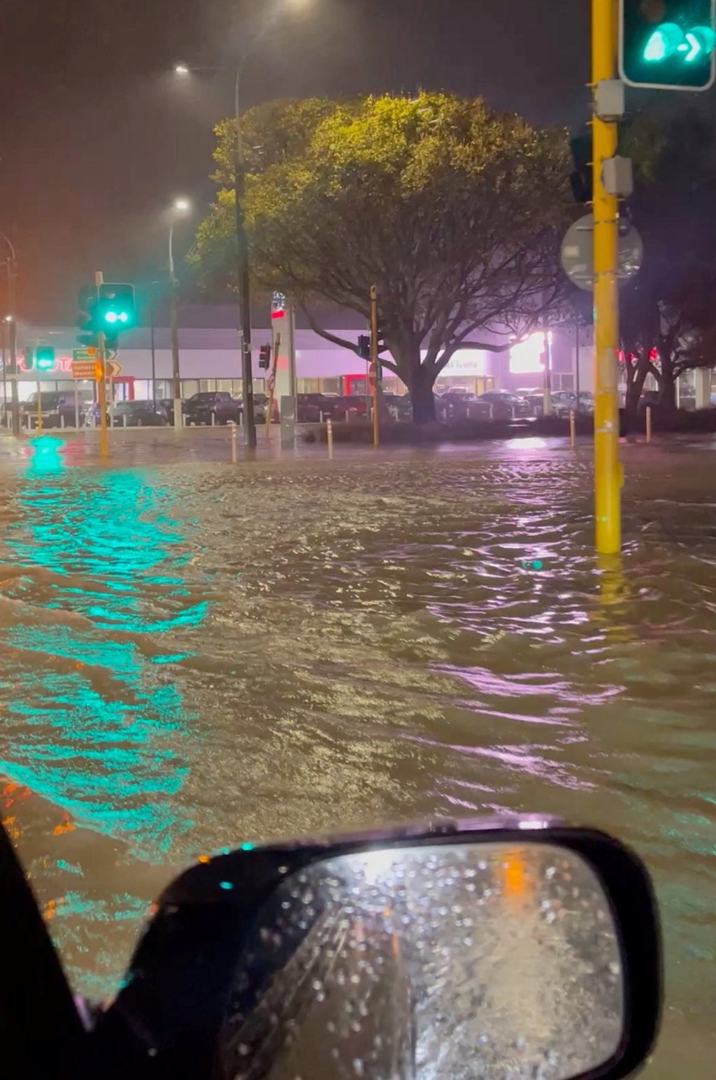 A car drives through a flooded road in Wellington, New Zealand, on Monday, in this screengrab taken from a social media video. Photo: Reuters