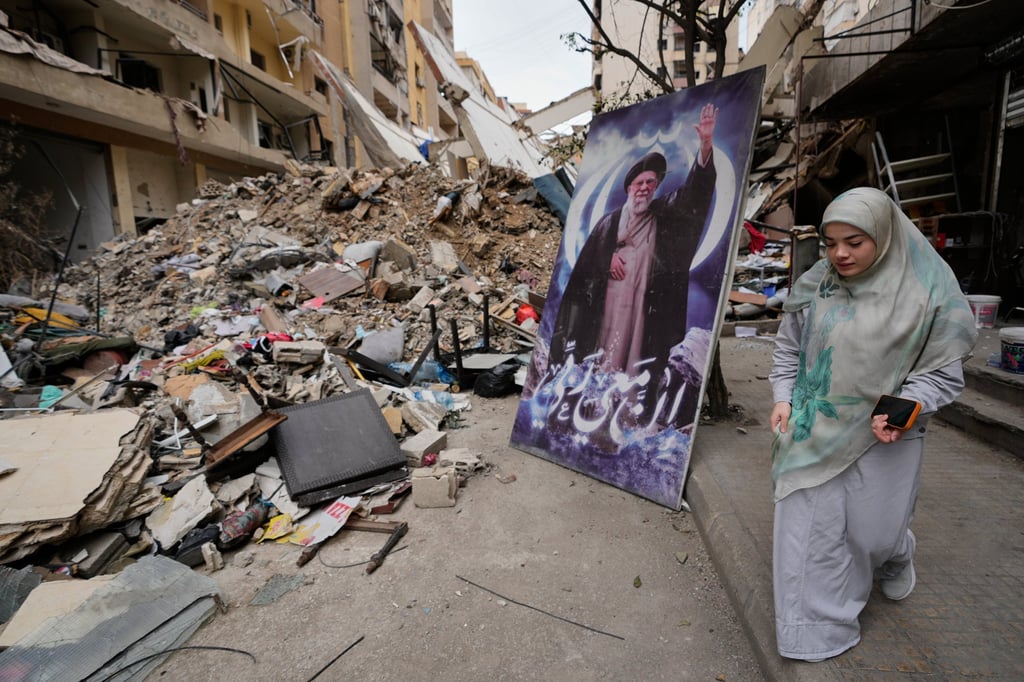 A poster of Ayatollah Ali Khamenei, the late supreme leader of Iran, in front of a destroyed building in Dahiyeh, Beirut’s southern suburbs. Photo: AP