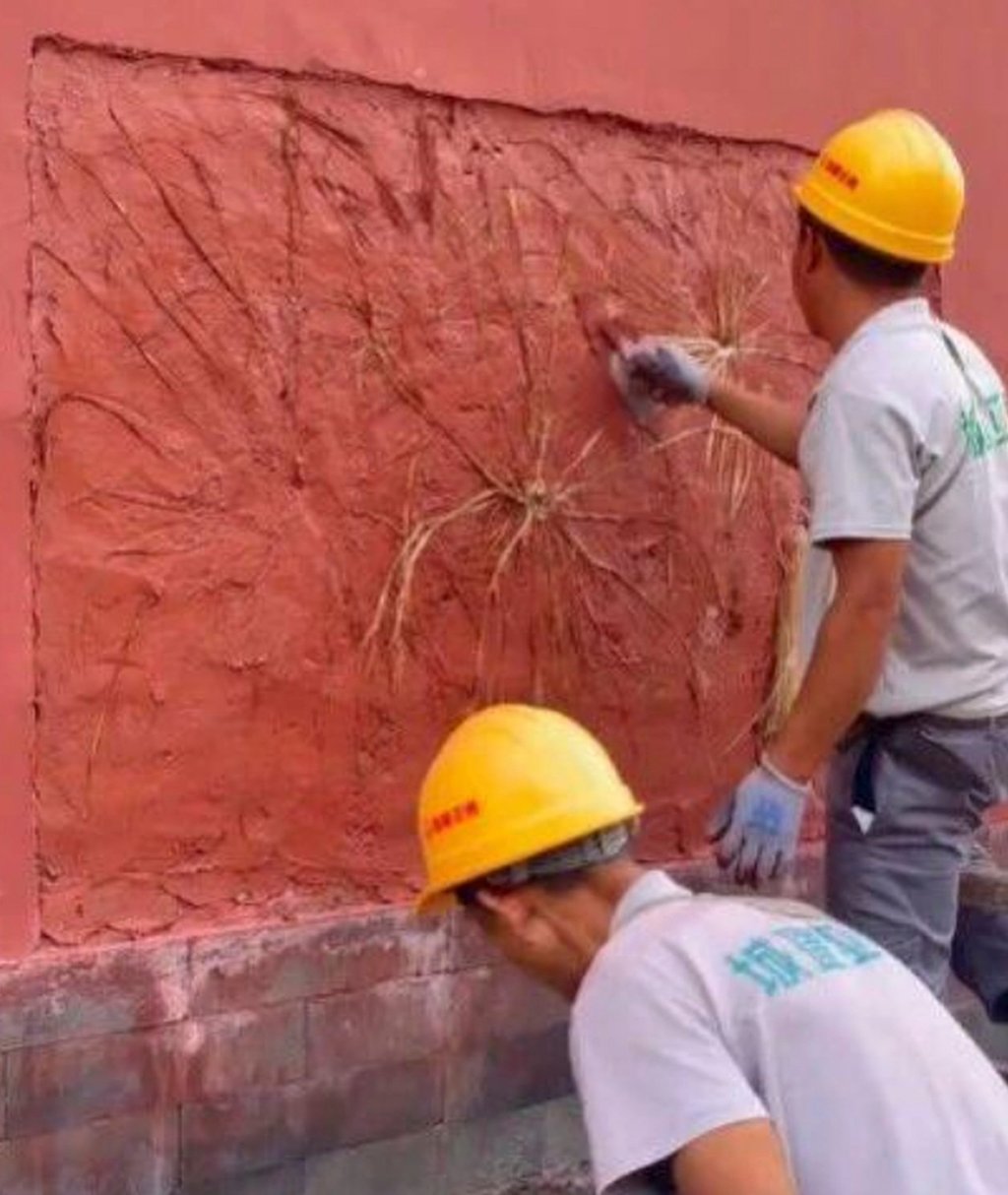 Two workers, one using a steel trowel, right, work on a wall at the Forbidden City. Photo: www.ettoday.net