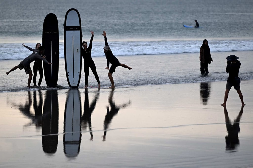 Tourists pose with their surfboards at Kuta beach near Denpasar on Indonesia’s resort island of Bali on April 8. Photo: AFP