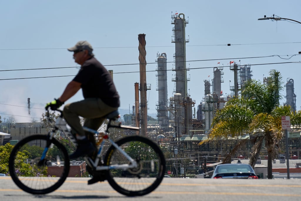 A cyclist rides past the Chevron refinery in El Segundo, California on April 17. US refiners rely on imported heavier blends to turn domestic light crude into exportable products like diesel and jet fuel. Photo: AP