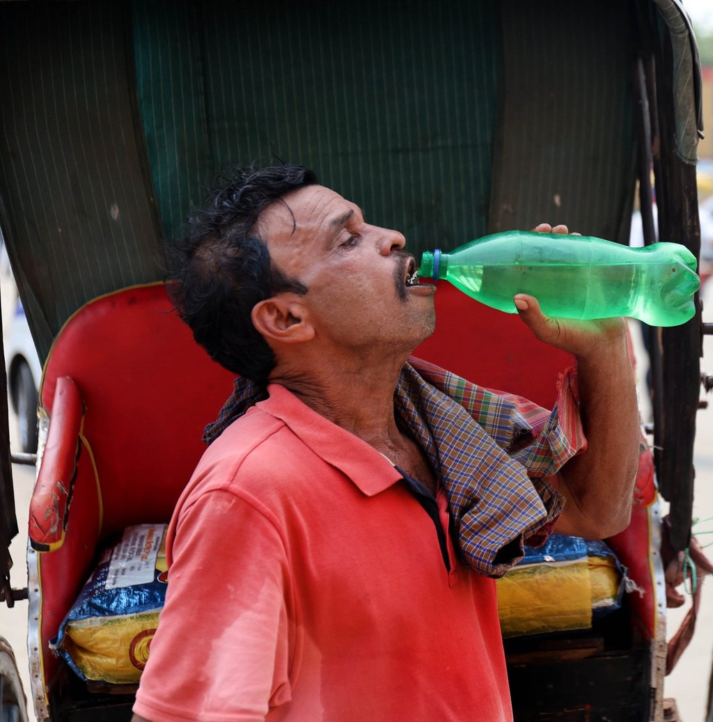 A rickshaw puller drinks water during a hot afternoon in Kolkata on Tuesday. Photo: EPA