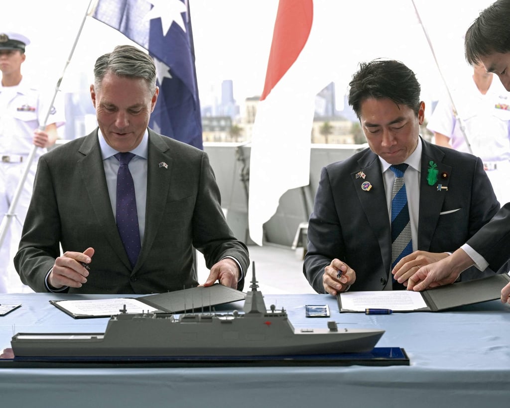 The defence ministers of Australia Richard Marles (left) and Japan Shinjiro Koizumi sign the contract for Japan to deliver the first three of Mogami-class warships in Melbourne on Saturday. Photo: AFP