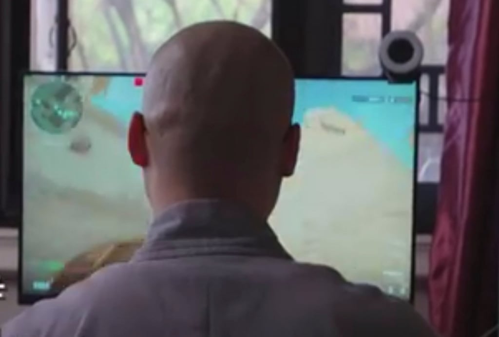 Venerable Huayan, above, is focused in front of his screen as he plays the game. Photo: Baidu