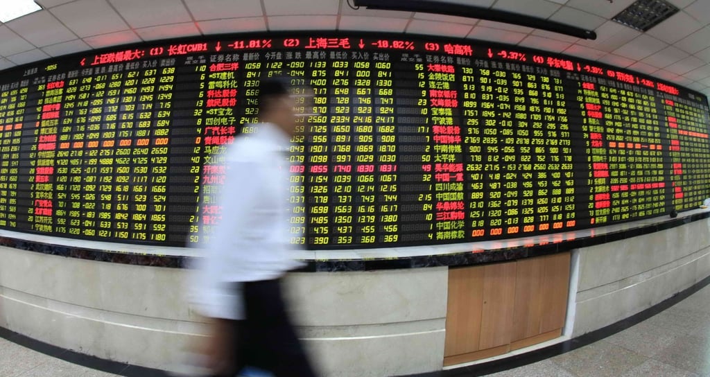 An investor passes by an electronic board displaying stock prices at a brokerage in Shanghai. Photo: Xinhua