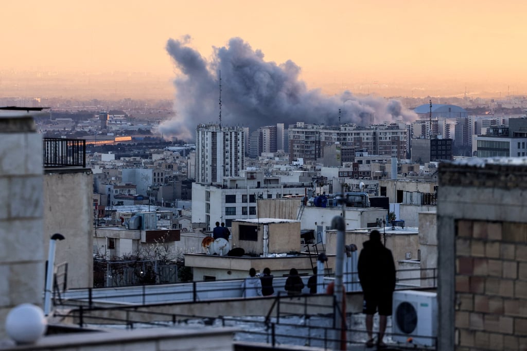 People watch a plume of smoke rise after a strike on the Iranian capital Tehran on March 3. Photo: AFP/Getty Images/TNS