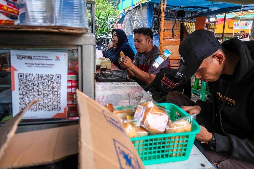 People eat lunch at a street food stall in Jakarta. For more than a decade, Indonesia’s economy has expanded at a reliable annual clip of 5 per cent. Photo: AFP