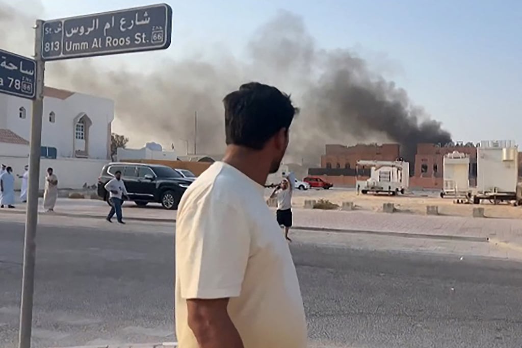 A man looks at smoke billowing from an explosions in Doha’s capital Qatar on September 9, 2025 after an Israeli air strike. Photo: AFPTV/AFP/Getty Images/TNS