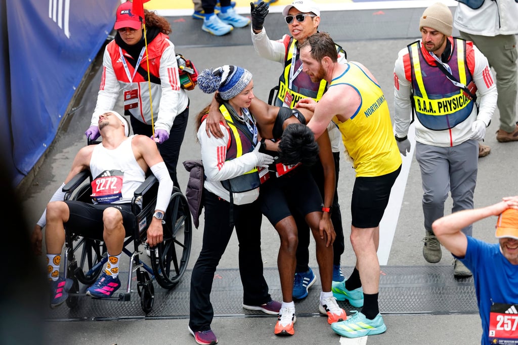 Robson De Oliveira (left) and Ajay Haridasse receive medical attention after the race. Photo: Reuters