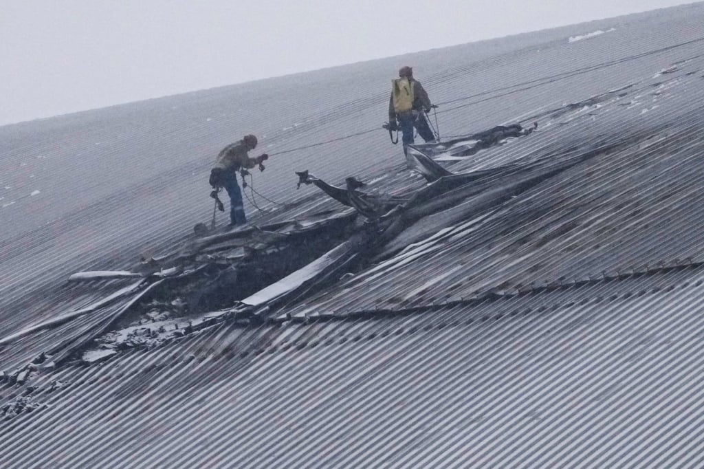 Workers inspect the damage to the roof of the new Security Building, which was built to store the radioactive remains of Reactor No. 4 at the Chernobyl nuclear power plant, following what Ukrainian officials said was a Russian drone attack on Chernobyl, Ukraine, on February 14 last year. Photo: AP