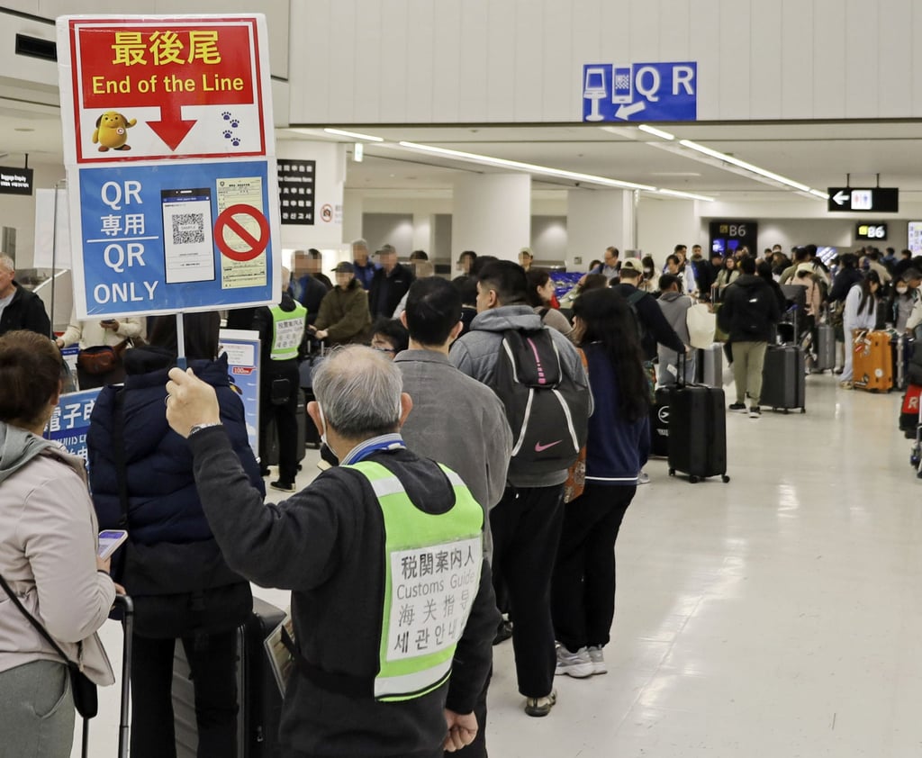 People wait in a line to go through electronic customs procedures at Narita International Airport on February 20. Photo: Kyodo