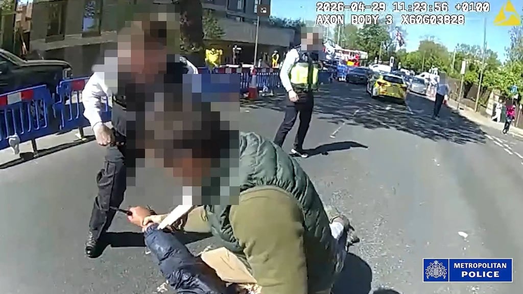 Police try to disarm a man holding a knife as they detain him in the street in the Golders Green neighbourhood on Wednesday, after he allegedly stabbed two people nearby. Photo: Metropolitan Police via AFP