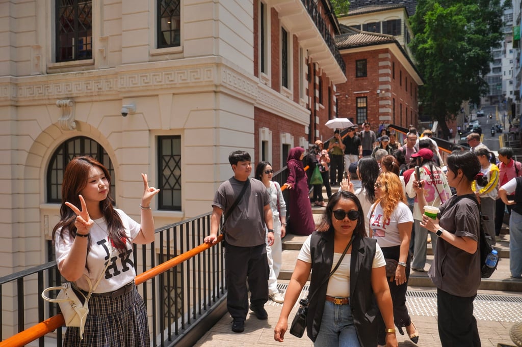 Tourists take pictures at the entrance of Tai Kwun in Central on Labour Day. Photo: Elson Li