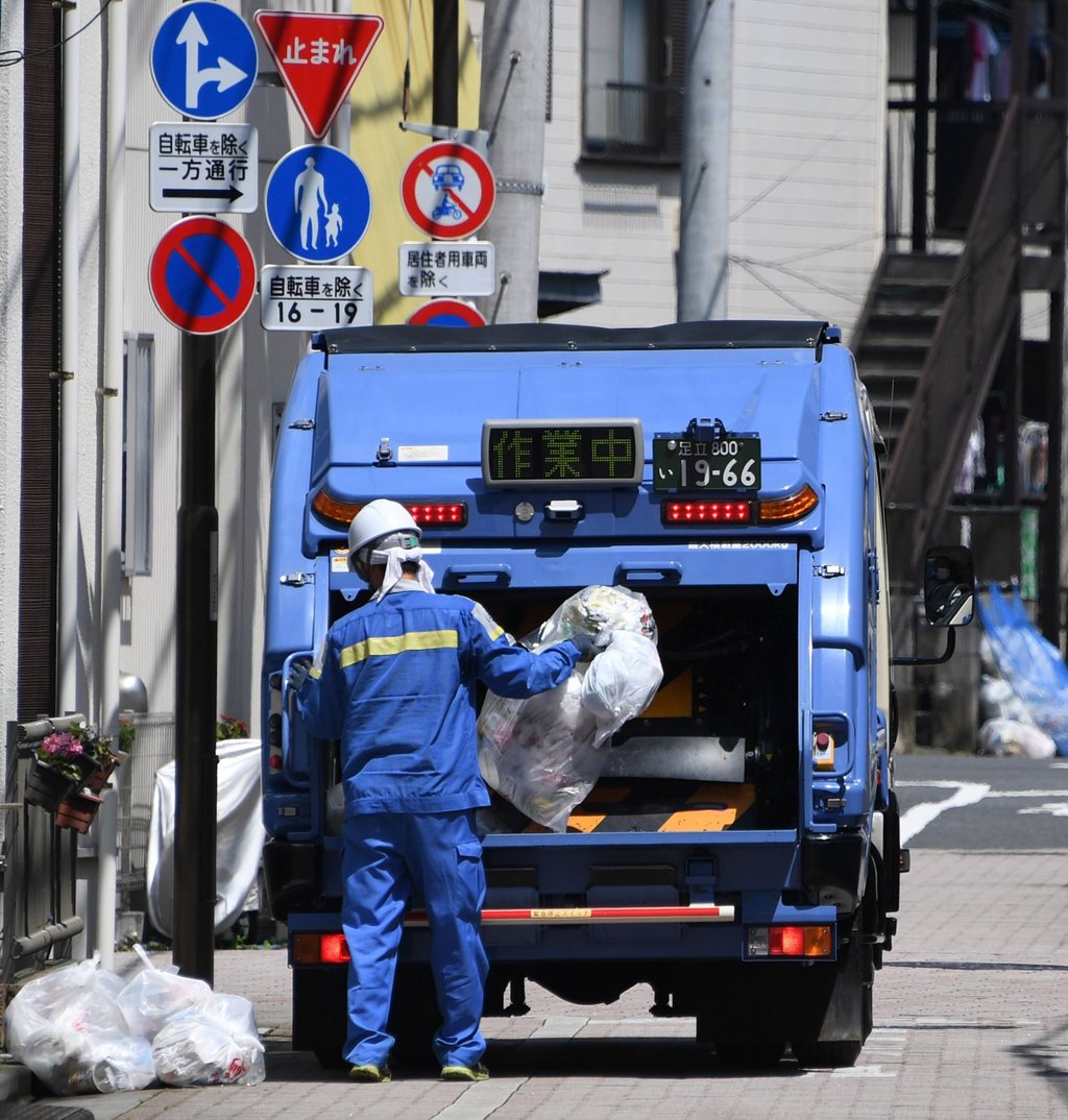 A city worker collects recyclables on a street in Tokyo. Photo: AFP