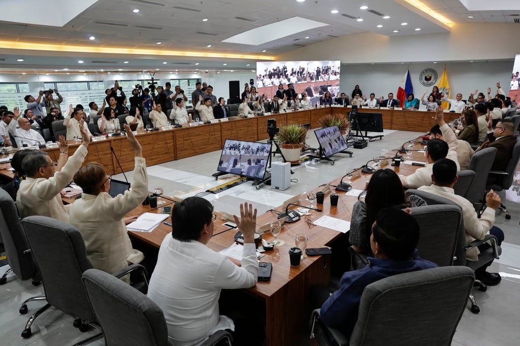 Members of the House of Representatives Justice Committee raise their hands to vote during a committee hearing in Quezon City, the Philippines, on Monday. Photo: EPA