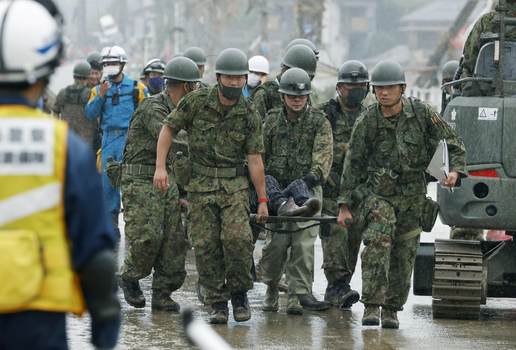 Japanese Self-Defence Force soldiers carry a person on a stretcher at a flooded site in Kuma village, Kumamoto, in 2020. Photo: Kyodo via Reuters