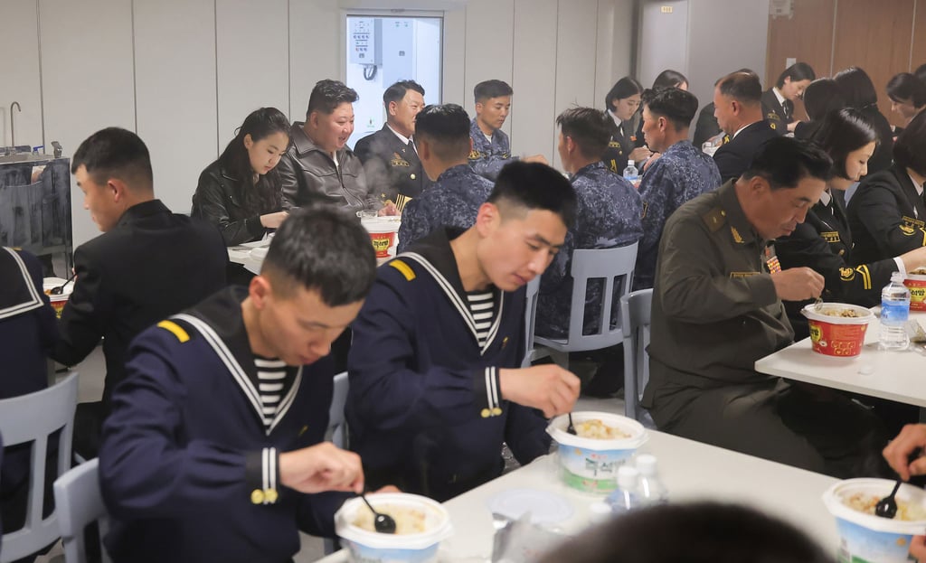 North Korean leader Kim Jong-un (rear centre) and his daughter have meal with sailors on the destroyer Choe Hyon on Thursday. Photo: KCNA/AP