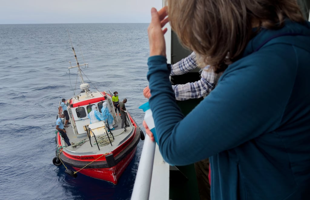 Passengers on the hantavirus-stricken cruise ship MV Hondius watch epidemiologists come aboard on Wednesday during their voyage to Tenerife. Photo: AP