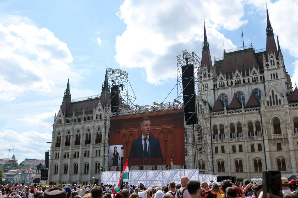 A screen shows the new leader of Hungary, Peter Magyar, delivering a speech on Saturday while a crowd gathers outside the parliament building in Budapest. Photo: Reuters