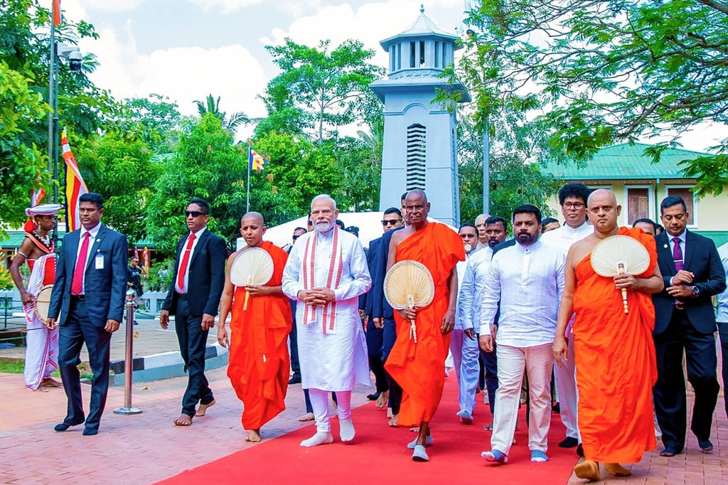 Buddhist monk Pallegama Hemarathana (C) walks next to Sri Lanka’s President Anura Kumara Dissanayake (4th R) and India’s Prime Minister Narendra Modi (4th L) at the Jaya Sri Maha Bodhi temple in Anuradhapura in 2025. Photo: Handout via AFP