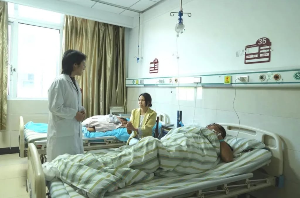 Ji Yaozhong lies in his hospital bed as a doctor tends to him alongside a visitor. Photo: ifeng.com