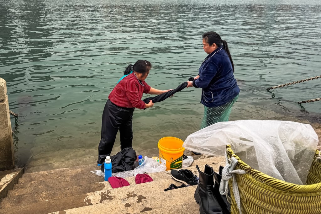Two Chinese women wash clothes in the Wu River in Chongqing’s Fuling district using traditional hand-washing techniques. Photo: Getty Images