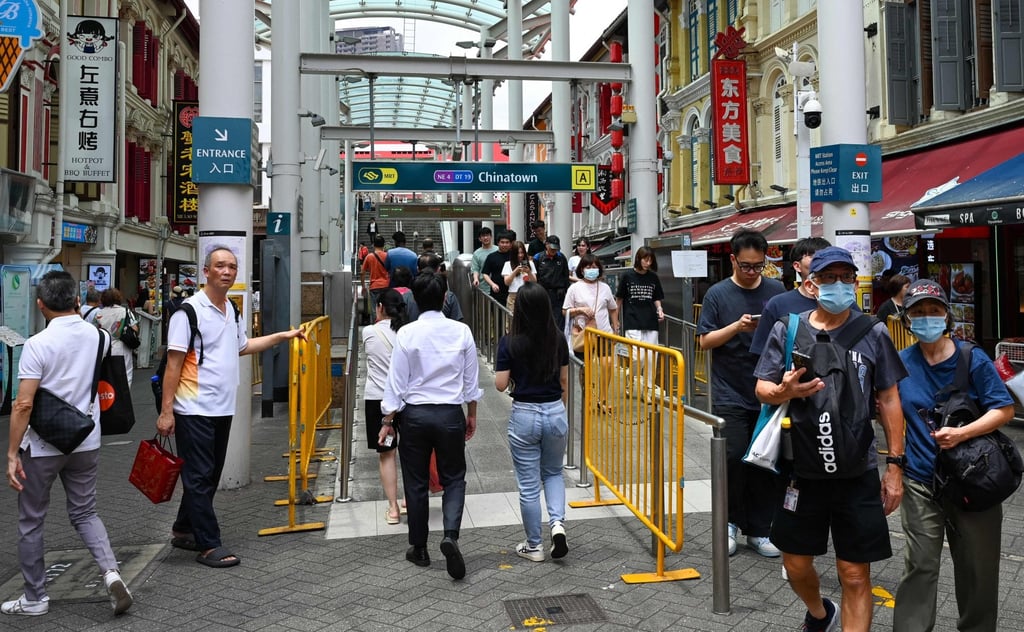 People walk along the street next to the Chinatown MRT station in Singapore on February 12. Photo: AFP
