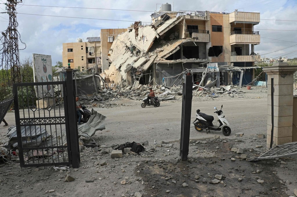 Motorists ride past the site of an Israeli air strike at the headquarters of a local NGO in Tyre, Lebanon, on Saturday. Photo: AFP