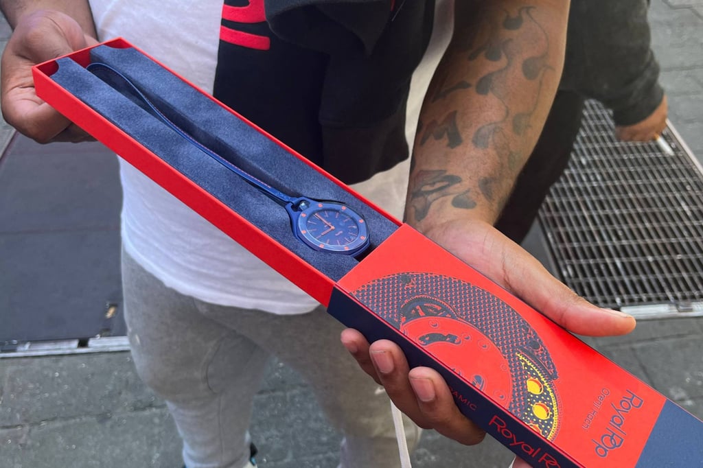A customer shows his “Royal Pop” watch outside a Swatch store in New York on Saturday. Photo: AFP
