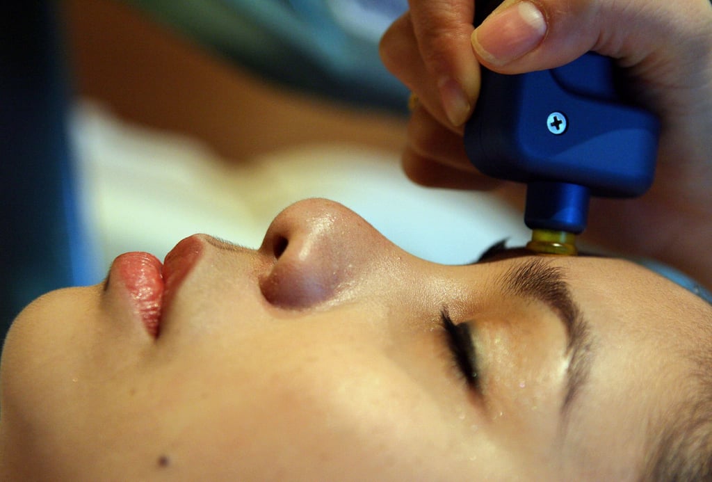 A Thai therapist gives facial treatment of deep laser stimulation to a client at a spa in central Bangkok. Photo: AFP