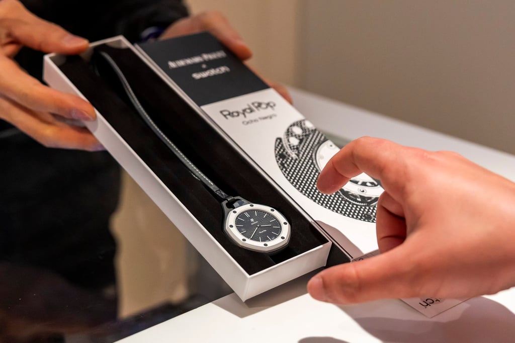 A saleswoman shows the new Royal Pop watch by Swatch and Audemars Piguet to a customer in Geneva, Switzerland, on May 16, 2026. Photo: EPA