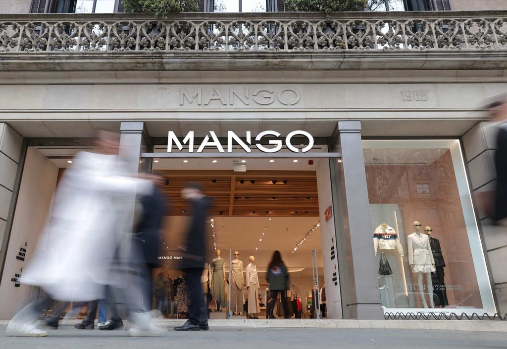 Pedestrians walk by the entrance of a Mango shop on Passeig de Gracia street in Barcelona. Photo: AFP