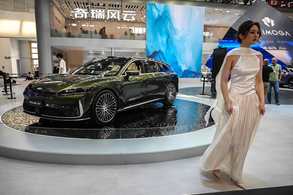 A woman walks near a Chery Fulwin A9L GT at the Beijing Auto Show on April 25. Photo: AFP
