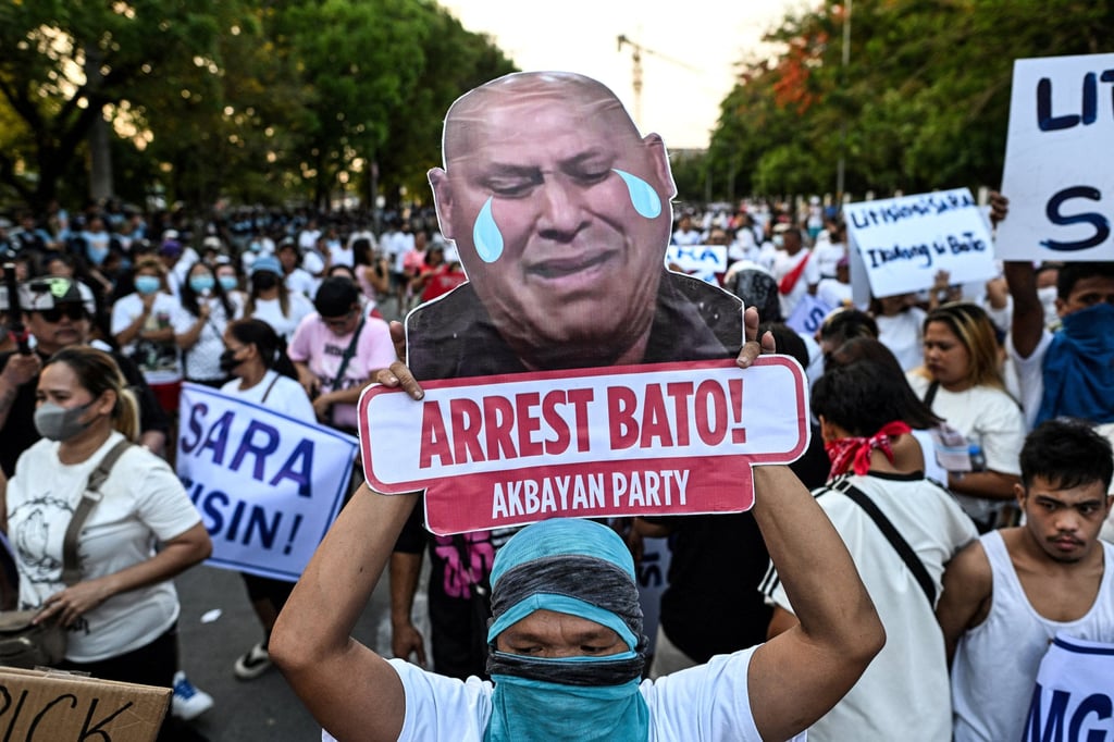 An activist displays a sign calling for the arrest of Senator Ronald “Bato” dela Rosa, on May 13 outside the Philippine senate. Photo: Reuters