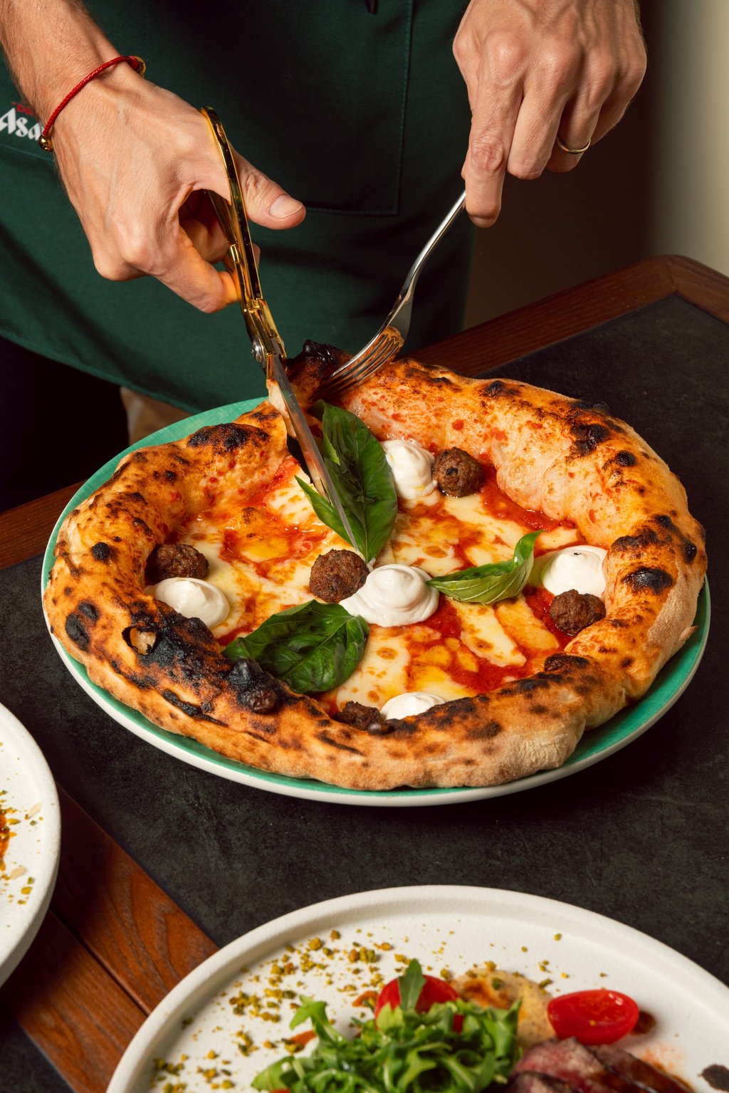 Vincenzo Capuano’s golden scissors slice through his signature Nuvola crust. Photo: courtesy Vincenzo Capuano