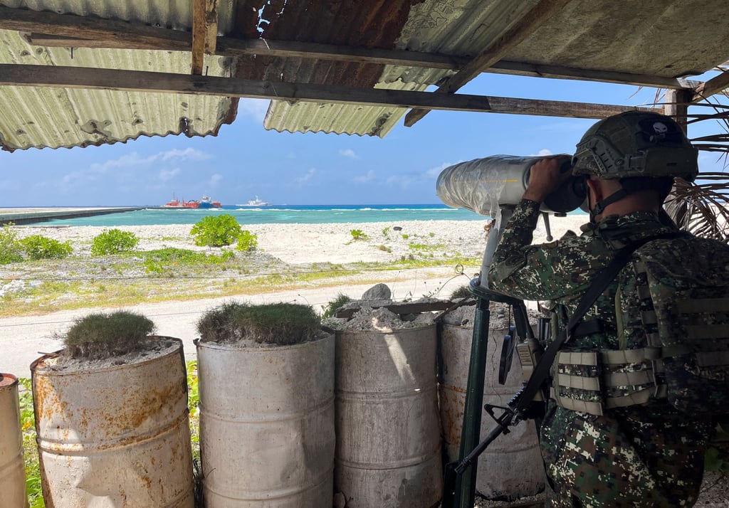A Philippine soldier peers through a telescope from a viewing deck in Philippine-occupied Thitu Island in the disputed South China Sea on February 21. Photo: Reuters