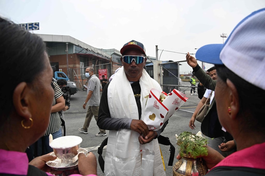 Nepali mountaineer Kami Rita Sherpa (middle), dubbed the “Everest Man”, arrives at Kathmandu’s Tribhuvan International airport on Friday after earlier this month climbing Everest for a record 32nd time. Photo: AFP Nepali mountaineer Kami Rita Sherpa (middle), dubbed the “Everest Man”, arrives at Kathmandu’s Tribhuvan International airport on Friday after earlier this month climbing Everest for a record 32nd time. Photo: AFP