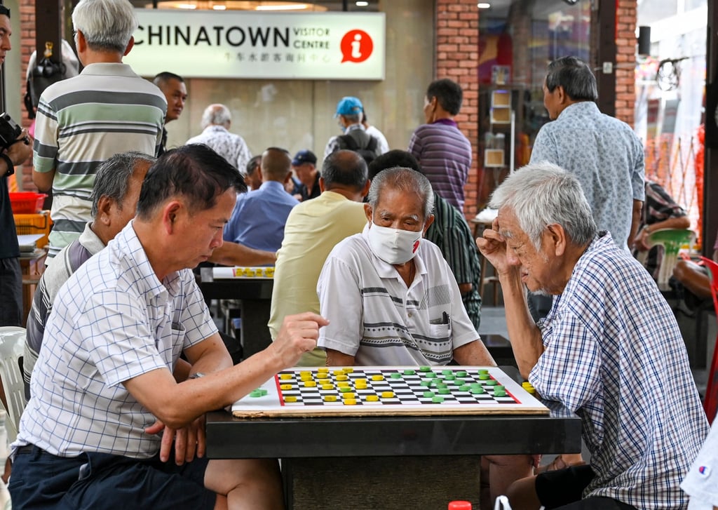 Elderly men play draughts in Singapore’s Chinatown on January 26, 2024. Photo: AFP