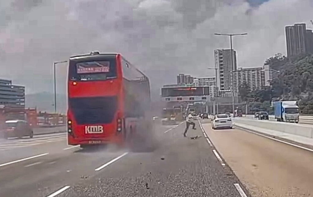 A screenshot from dashcam footage shows a worker scrambling out of the path of the bus towards the concrete median in the middle of the highway. Photo: Handout