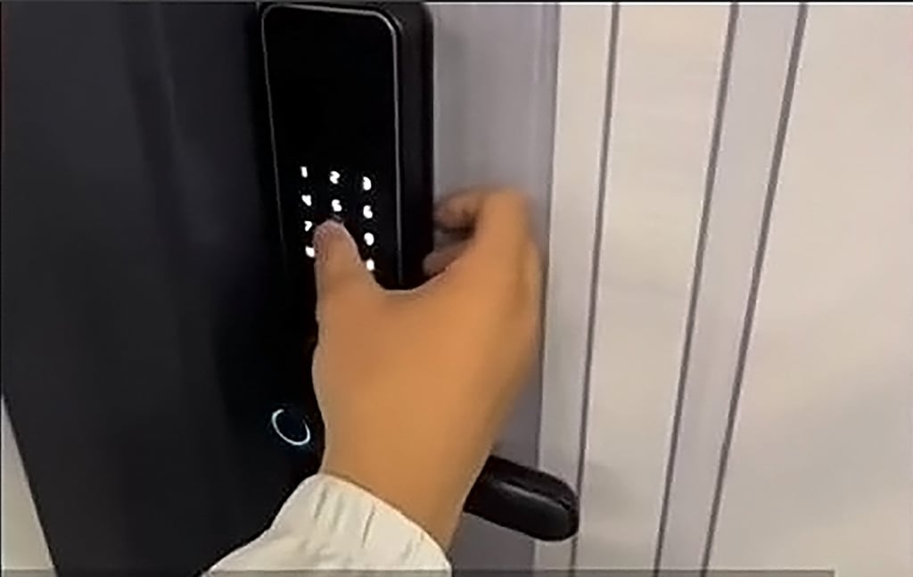 The property agent Tang, above, punches in the passcode to open the front door of the flat. Photo: Baidu