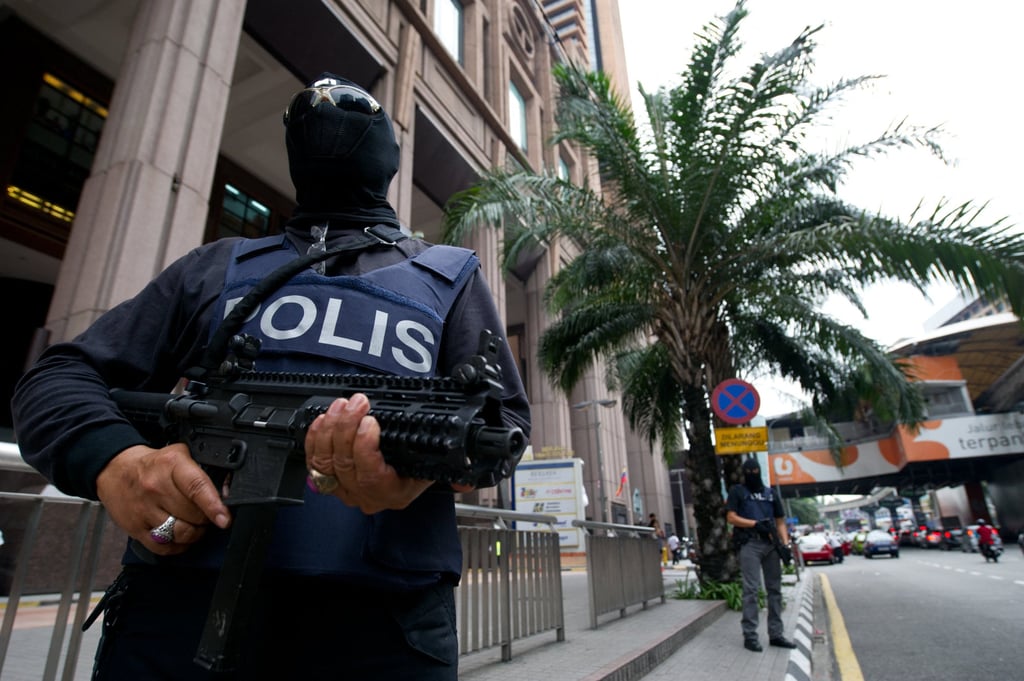 Malaysian policemen stand guard during an operation in downtown Kuala Lumpur. Photo: AFPi