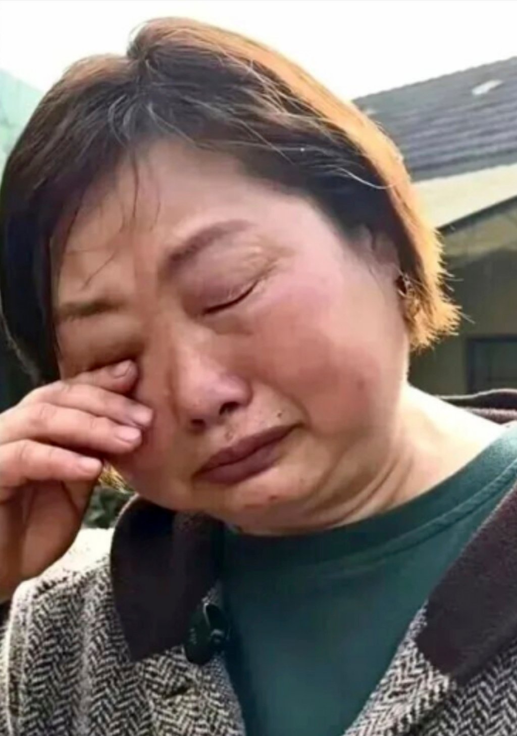 Village official Xiang Jinyuan wipes away her tears as she talks about the flood damage. Photo: Sohu