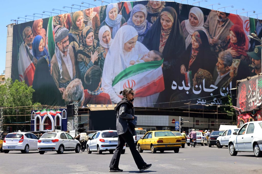 A woman crosses a street near a large political billboard in central Tehran on Tuesday. Photo: AFP A woman crosses a street near a large political billboard in central Tehran on Tuesday. Photo: AFP