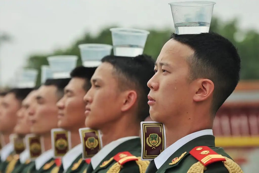 A row of ceremonial soldiers standing still with glasses of water on their heads during training. Photo: bjd.com A row of ceremonial soldiers standing still with glasses of water on their heads during training. Photo: bjd.com