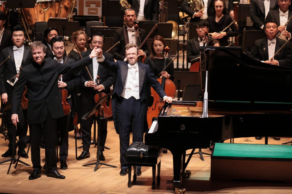 Conductor Daniel Harding (centre) raises his hand with pianist Paul Lewis after a performance with the Hong Kong Philharmonic Orchestra at the Hong Kong Cultural Centre in 2025. Photo: Keith Hiro/HK Phil