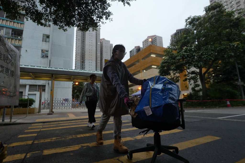 A care team member (front) helps a resident move her belongings from Wang Chi House of Wang Fuk Court on May 15. The building was the only block left largely unscathed in last year’s deadly Tai Po fire. Photo: Sun Yeung A care team member (front) helps a resident move her belongings from Wang Chi House of Wang Fuk Court on May 15. The building was the only block left largely unscathed in last year’s deadly Tai Po fire. Photo: Sun Yeung
