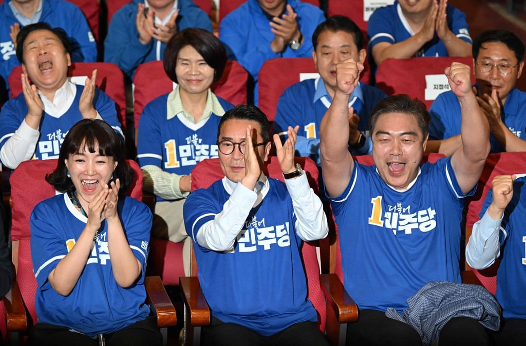 South Korea’s ruling Democratic Party members and lawmakers react as they watch results of exit polls in Seoul on Wednesday. Photo: AFP